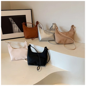 Minimalist half-moon crossbody bags in caramel, silver, beige, cream, and black