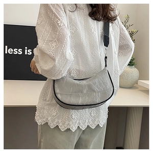 Detailed view of light gray crescent shoulder bag with textured fabric and wide strap