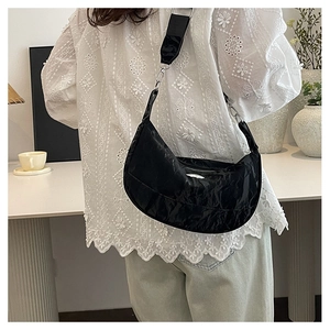 Minimalist black crescent moon shoulder bag with adjustable strap and pleated glossy finish