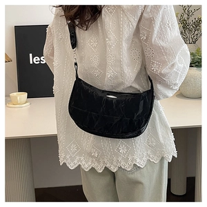 Detail of black crescent shoulder bag with pleated texture and silver metal decoration