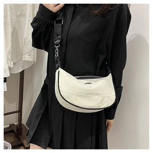 Minimalist cream crescent crossbody bag with black trim and wide canvas shoulder strap