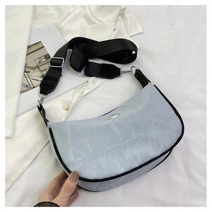 Detail of light blue wrinkled texture fabric and metallic logo on the crescent bag