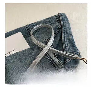 Detail of silver faux leather bag strap with adjustable gold metal lobster clasps