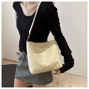 Detail of cream leather patchwork tote bag showing geometric texture and soft finish