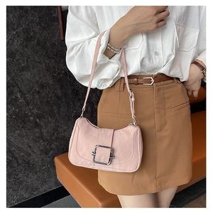 Pink underarm baguette bag with leaf embossed pattern and silver buckle on model