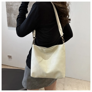 Schicke cremefarbene Handtasche mit Karomuster und Goldbeschlägen an der Schulter