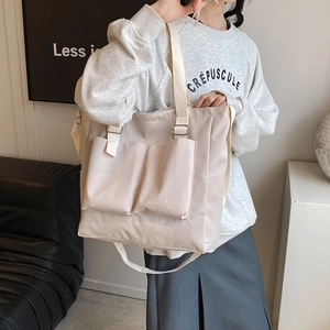 Large beige nylon tote bag with utility pockets and adjustable straps for daily commute