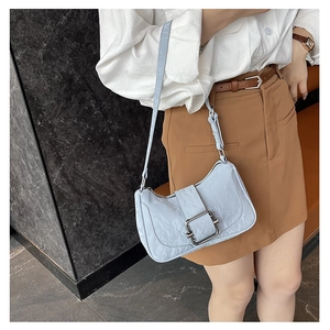 Detail of light blue pleated leather shoulder bag featuring a silver square metal buckle