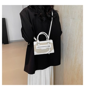 Modèle portant un mini sac tissé avec finitions en cuir blanc et fine bandoulière réglable