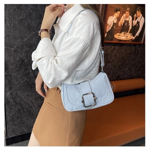 Detailed view of light blue textured leather underarm bag with silver square buckle