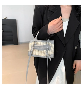 Détail du sac patchwork en paille tressée et cuir gris avec garnitures métalliques