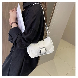 Detail of white wrinkled leather shoulder bag with silver square metal buckle and strap
