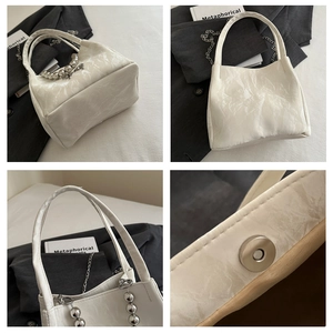 Detail showing off-white glossy leather bag, silver bead chain, and magnetic closure