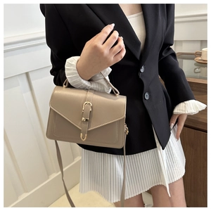 Détail du petit sac carré kaki avec boucle dorée vintage et texture mate élégante