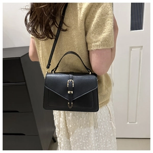Détails du sac à main en cuir noir texturé avec fermoir doré et poignée supérieure fixe