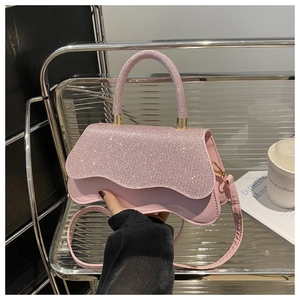 Detailed macro of pink sequin handbag featuring wavy flap and luxury rhinestone handle