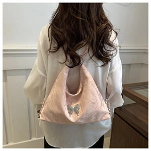 Detail of light pink shoulder bag with marble texture and silver butterfly buckle