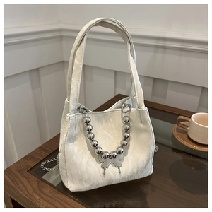Elegant off-white bucket bag with pleated texture and silver butterfly pendant detail