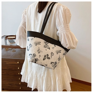 Detail view of large butterfly print tote bag with black contrast straps and handles