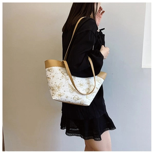 Detail view of butterfly and constellation printed tote bag with leather straps and edges