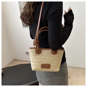 Detailaufnahme der Stroh-Tote-Bag mit beiger Webstruktur und braunem Lederbesatz