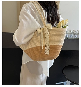 Detail of hand-woven bicolor tote bag featuring white lace bow and elegant tulip decor