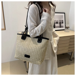 Detailansicht der gewebten Stroh-Tote-Bag mit schwarzem Kunstlederbesatz und Schultergurt