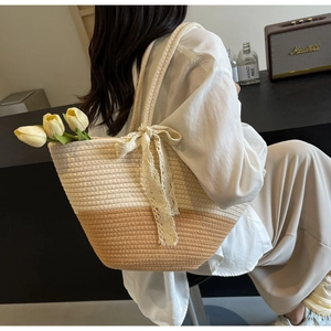 Detailed close-up of woven tote bag featuring cream and brown contrast with lace bow detail