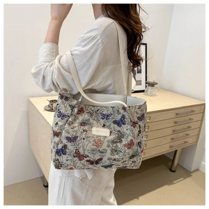 Ethnic woven canvas tote bag featuring colorful butterfly patterns and leather straps