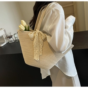 Detail of beige woven tote bag with lace bow and internal tulip floral decoration