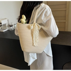 Contrast woven tote bag with lace bow and dual handles for a rustic summer beach style