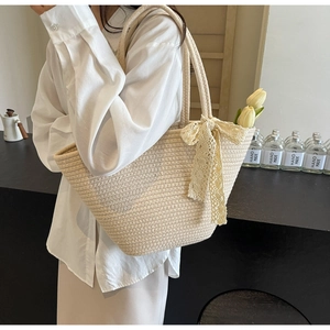 Close-up of beige woven tote bag with white lace bow and tulips in pastoral style