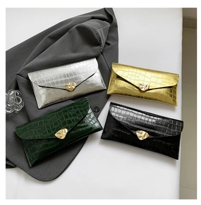 Détails de quatre pochettes enveloppes à motif crocodile avec boucles dorées élégantes