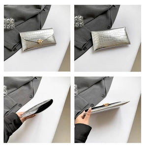 Vue détaillée de la pochette enveloppe argentée à motif crocodile et fermoir doré