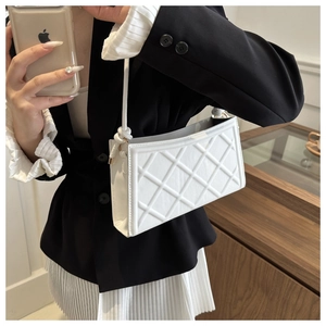 Détail du sac à bandoulière matelassé blanc montrant la texture et le profil fin