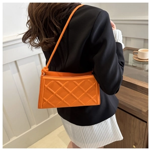 Gros plan du sac bandoulière matelassé orange avec détail de nœud sur le mannequin