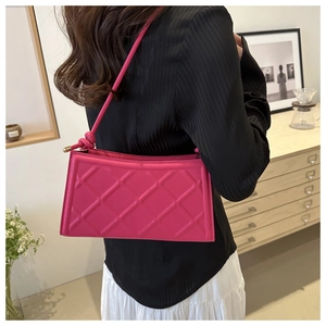 Détail du sac baguette matelassé rose vif avec bandoulière nouée et design minimaliste