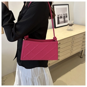 Détail du sac à bandoulière matelassé fuchsia avec nœud élégant sur la bandoulière