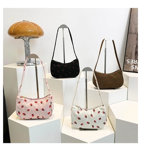 Détail des sacs demi-lune en velours côtelé avec broderie fraise en quatre coloris