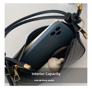 Internal view of minimalist black leather shoulder bag showing capacity for phone and accessories