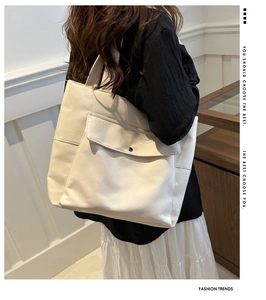 Détail d'un grand sac cabas en toile montrant la poche avant avec bouton pression métal