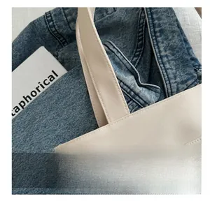 Gros plan sur les coutures renforcées et la texture de ce sac cabas beige pour femme