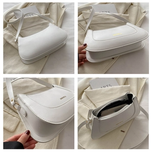 Detail view of white leather shoulder bag with gold zipper and interior pocket