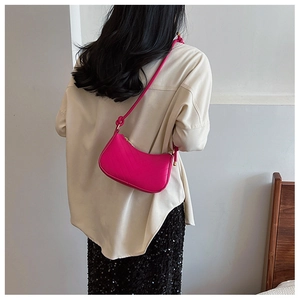 Detail of rose pink shoulder bag with V-shaped embossed lines and gold buckle strap
