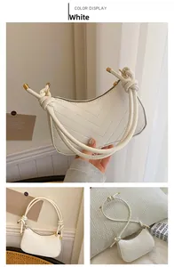 Detail of white quilted half-moon shoulder bag with knotted strap and gold hardware