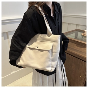 Détail du sac cabas en toile avec poche avant à rabat et bouton métallique vintage