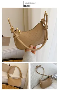 Detail of khaki leather underarm bag featuring V-shaped quilting and knotted strap design