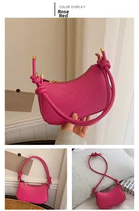 Detail of rose red half-moon shoulder bag with V-quilted pattern and gold hardware