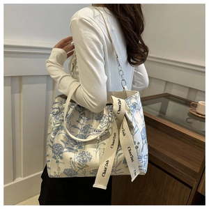 Detail of floral canvas tote bag with detachable shoulder strap and yellow ribbon charm