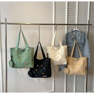 Large canvas tote bags with colorful letter embroidery in four soft pastel colors